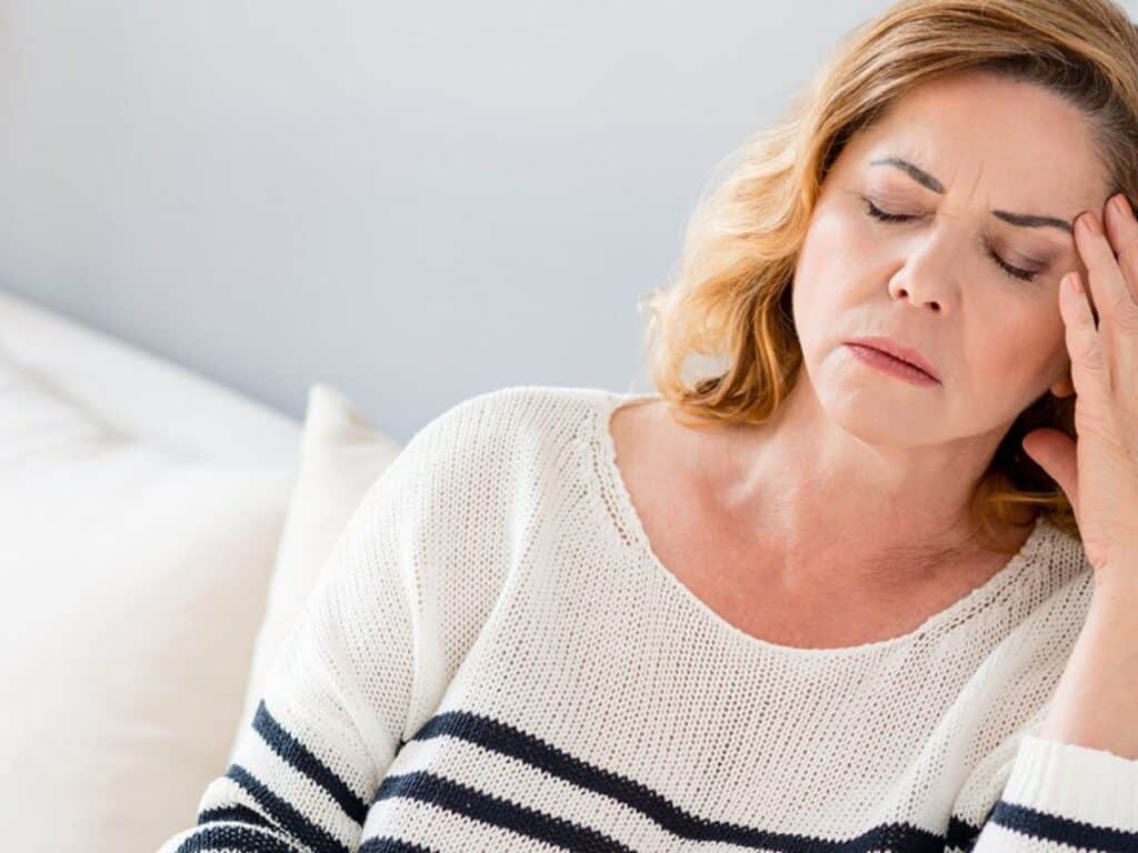 Femme qui ressent des troubles psychosomatiques